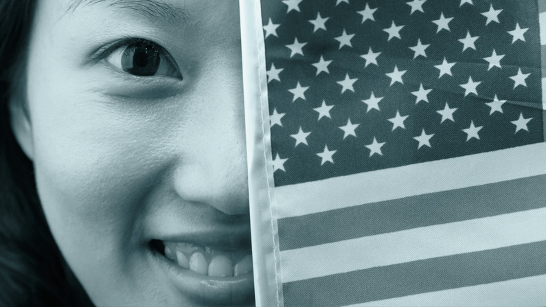 Elections translation image of Woman smiling looking from behind a USA flag