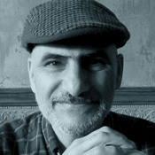 Black and white photo of Luis smiling wearing hat